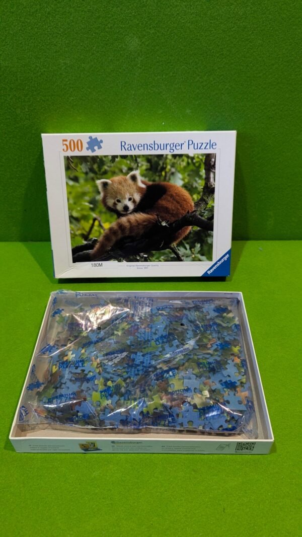 Caja de puzzle Ravensburger con panda rojo.