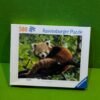 Caja de rompecabezas Ravensburger con panda rojo.