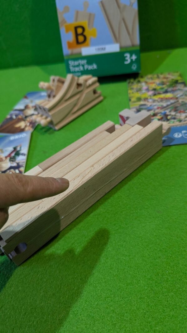 PXL_20251120_120356475.MP_-scaled-1.jpg Piezas de pista de tren de juguete en caja.