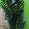 Planta artificial alta con hojas verdes brillantes.
