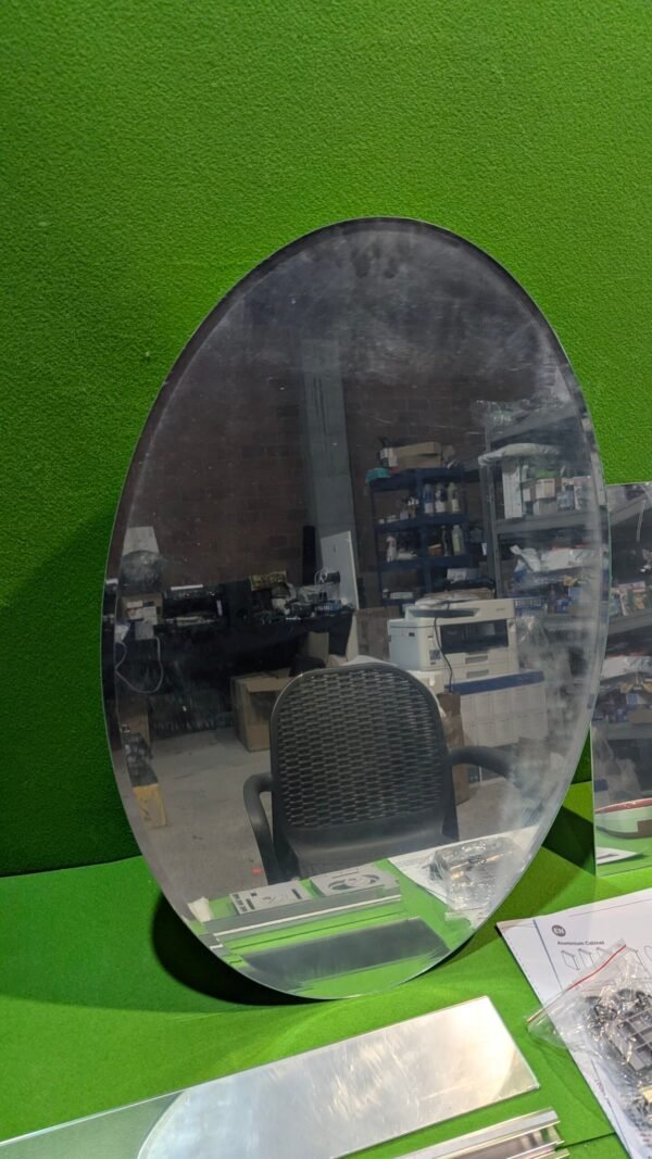 Espejo ovalado en entorno de oficina industrial.