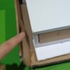 Persona señalando embalaje de cartón con tablero dentro