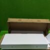 Panel blanco sobre caja de cartón en fondo verde.