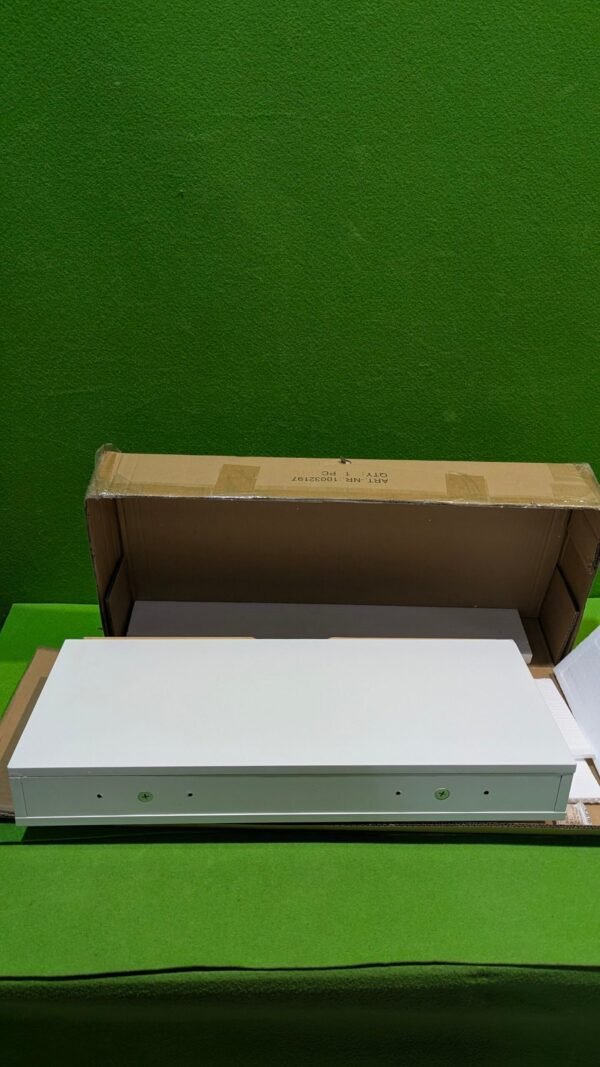 Panel blanco sobre caja de cartón en fondo verde.
