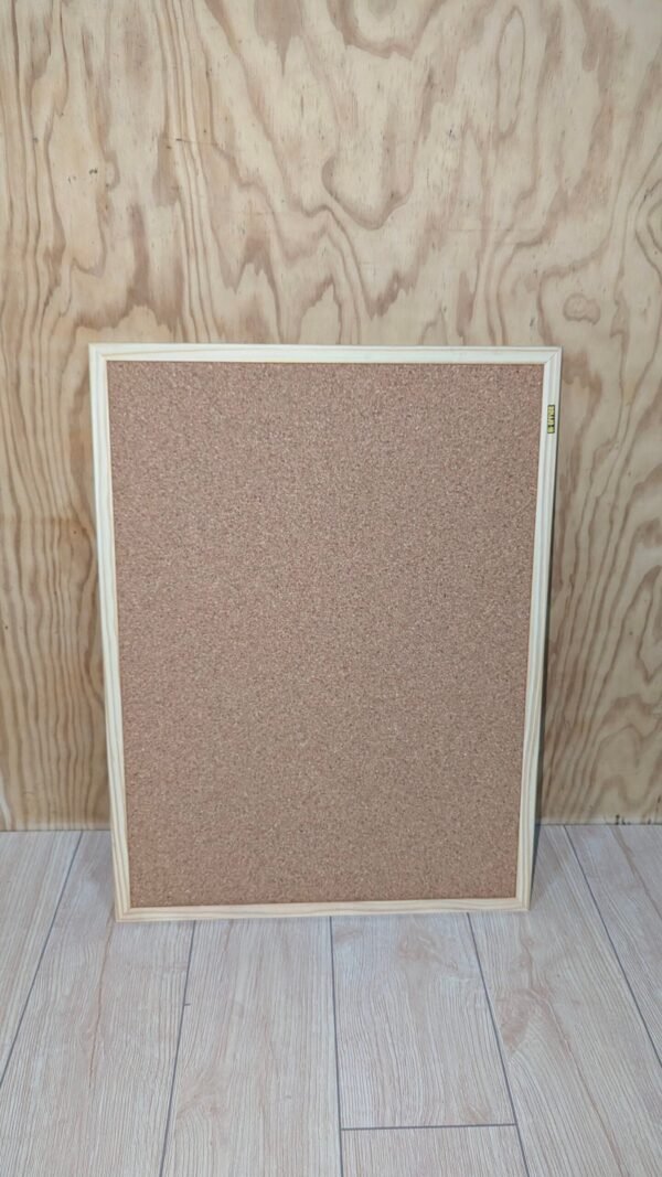 Pizarra de corcho vacía sobre fondo de madera.