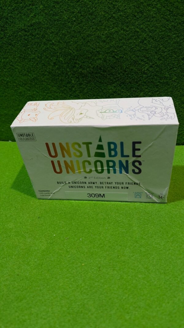 PXL_20251211_185449937-scaled-1.jpg Caja del juego Unstable Unicorns en mesa verde.