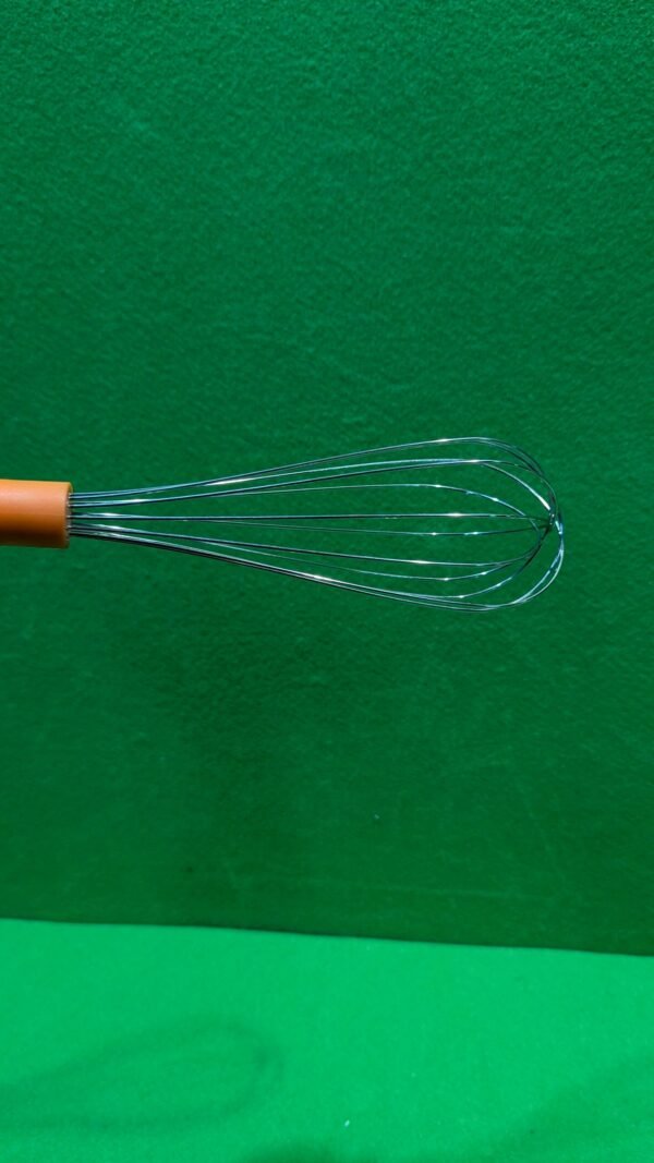 Batidor de cocina sobre fondo verde