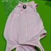 Camiseta rosa para perro sobre césped verde