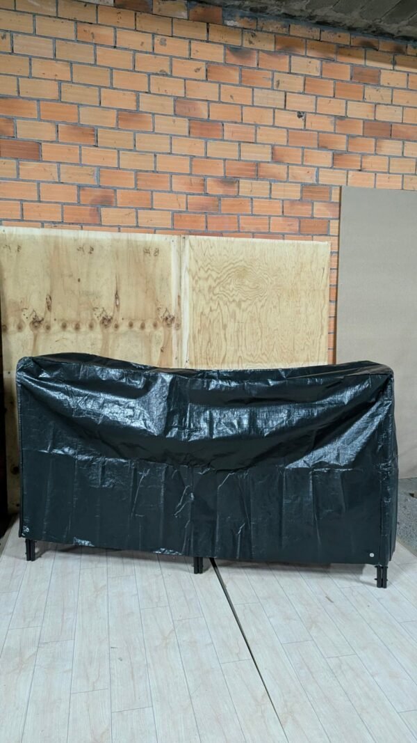 Barbacoa cubierta con funda negra en garaje