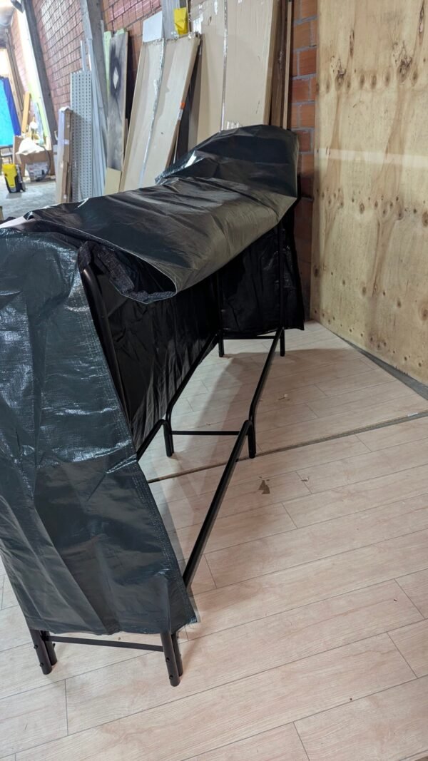 Mesa plegable cubierta con lona negra en almacén.