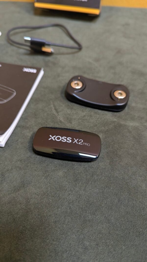 Sensor de velocidad XOSS X2 Pro y accesorios en mesa.