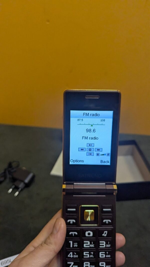 Teléfono plegable con radio FM 98.6 MHz.