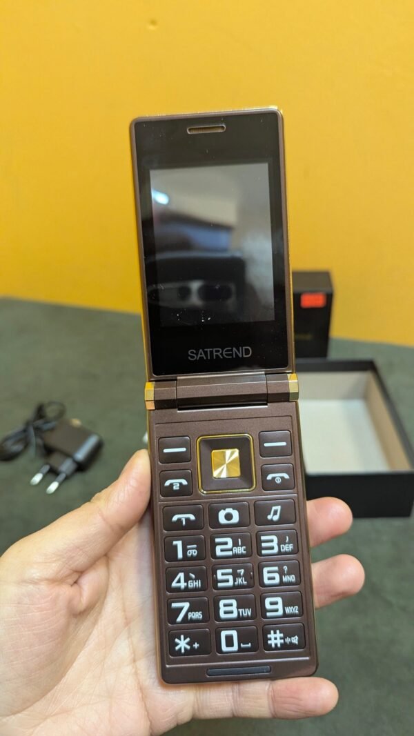 Teléfono móvil plegable marrón en una mano.