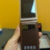 Teléfono móvil plegable vintage en mano.