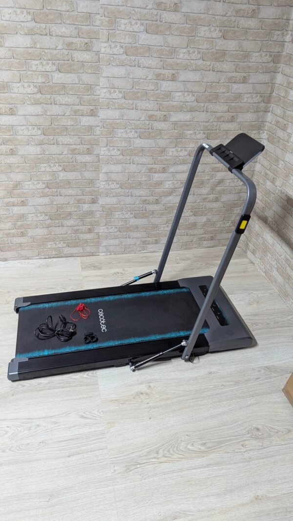 Cinta de correr plegable en habitación con pared de ladrillo.