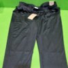Pantalones deportivos negros con etiquetas sobre césped verde.