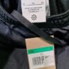 Pantalón deportivo negro, etiqueta de tallas y origen.