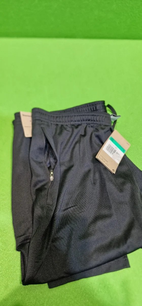 Pantalones negros deportivos en fondo verde
