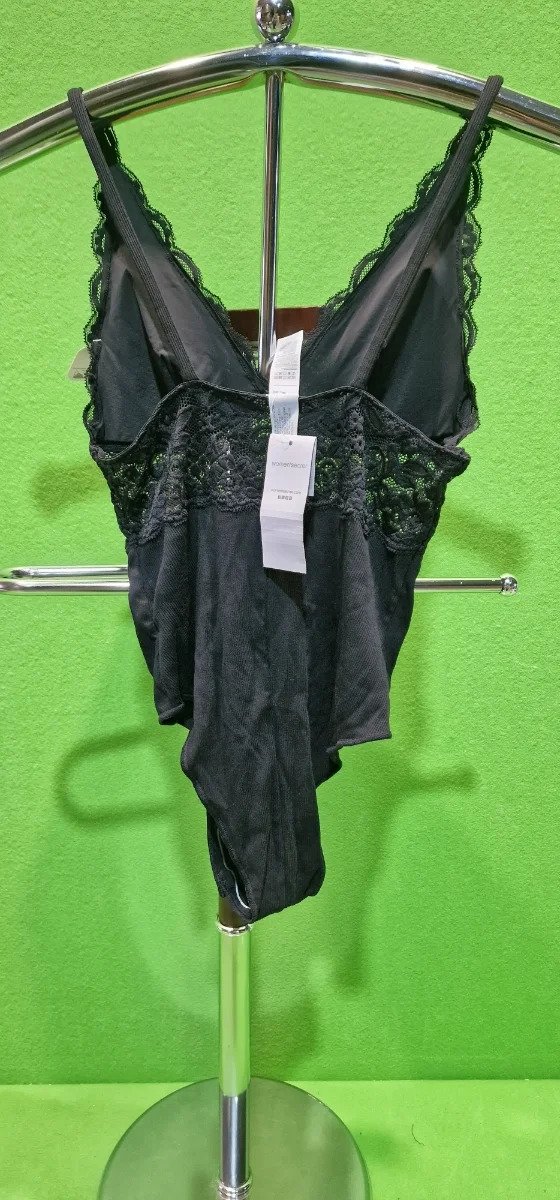 Body negro de encaje exhibido en percha.