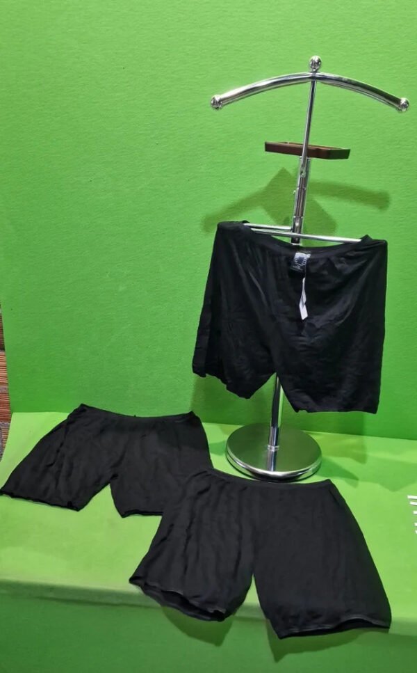 i3523540861.webp Pantalones cortos negros sobre fondo verde