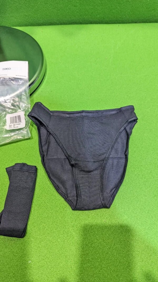 Ropa interior negra sobre superficie verde