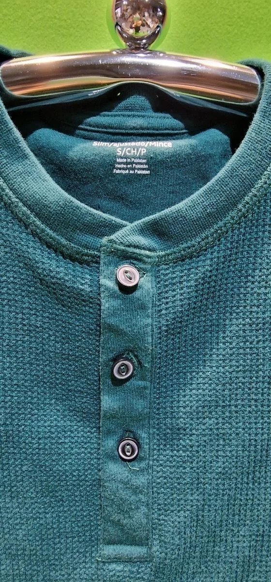 Camisa verde con botones en percha.