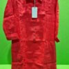 Camisa roja colgada sobre fondo verde.