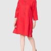 Mujer con vestido rojo de manga larga.