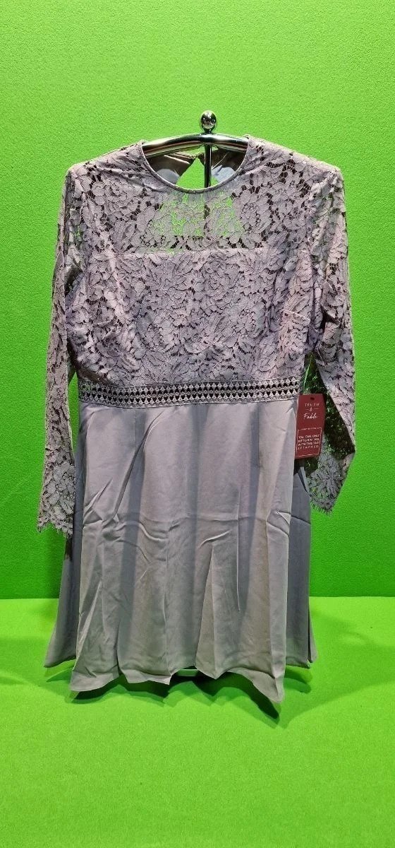 Vestido gris de encaje colgado en percha.