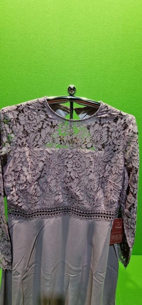 Vestido gris con encaje y etiquetas colgantes.