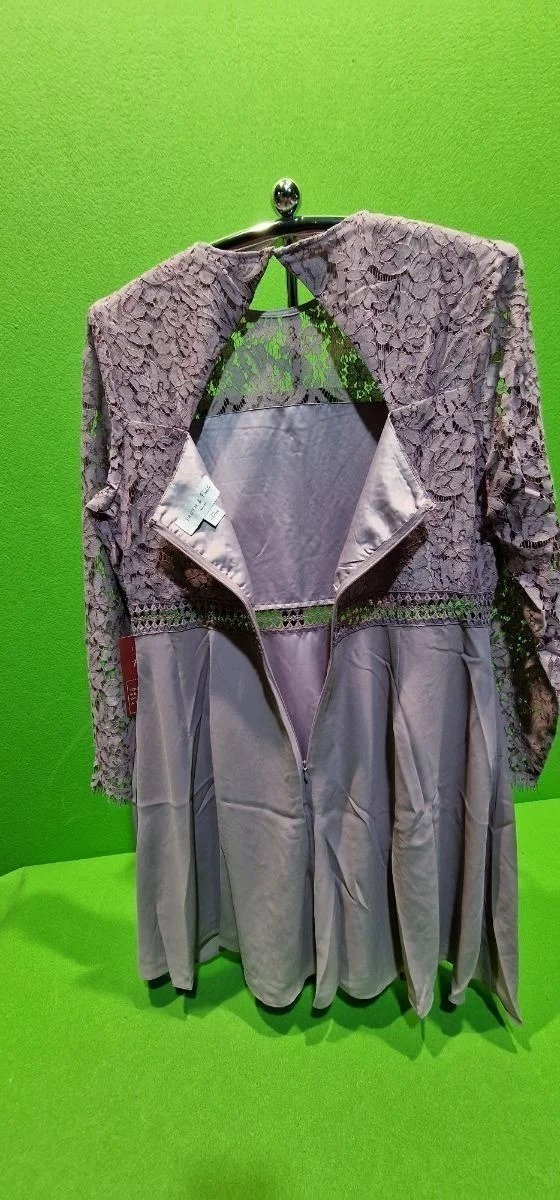 Vestido gris con encaje sobre fondo verde.