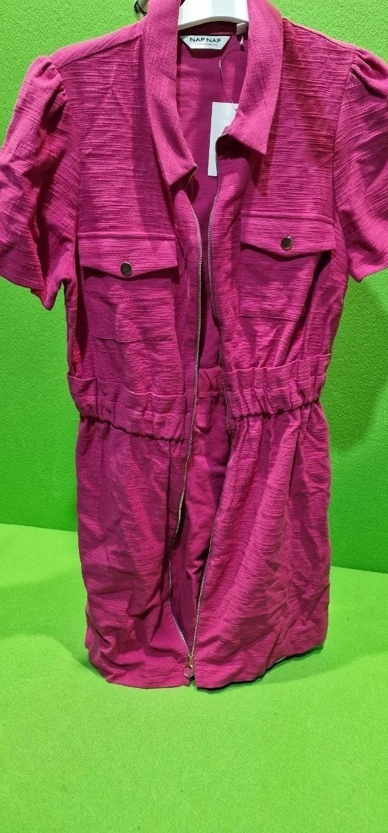 i5400926673.webp Vestido fucsia con cremallera y bolsillos, fondo verde.