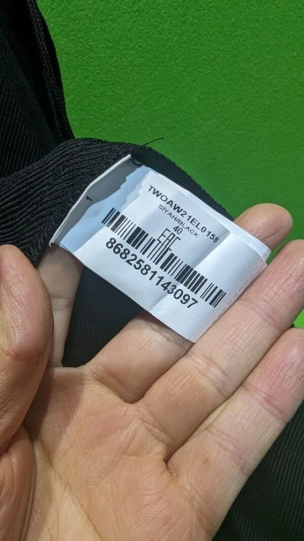 Etiqueta de ropa negra con código de barras.