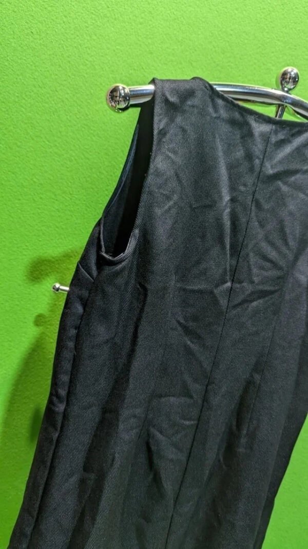 Blazer negro sobre fondo verde vibrante.