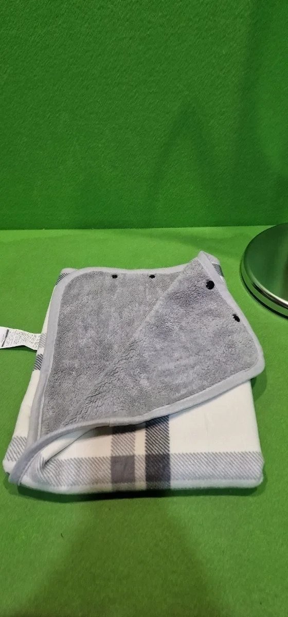 Toalla gris y blanca sobre fondo verde