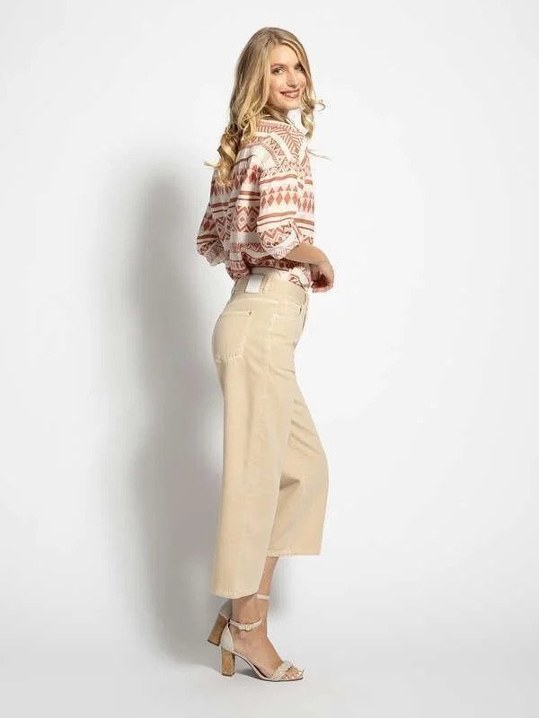 Mujer con camisa estampada y pantalones beige