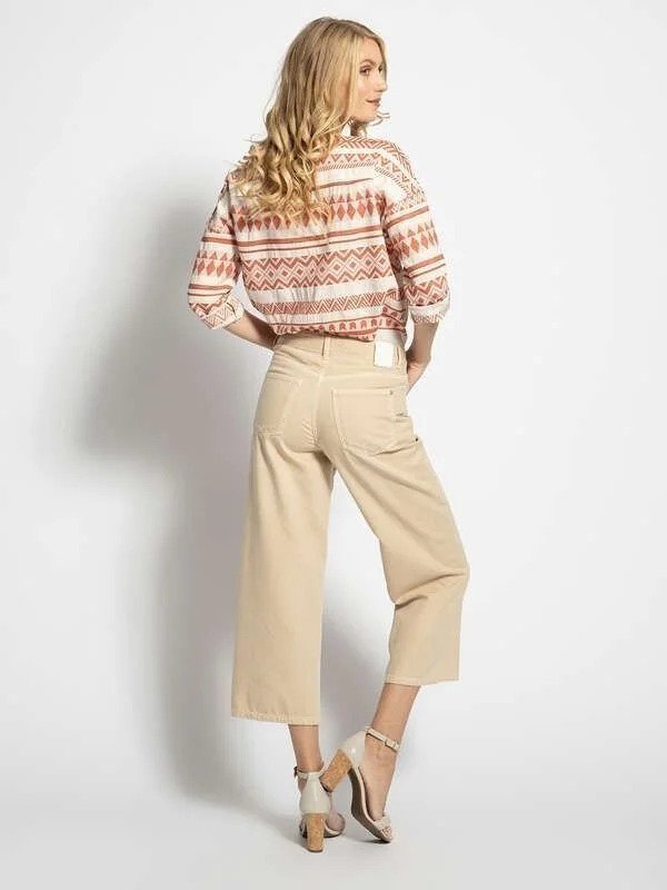 Mujer con conjunto beige y estampado geométrico.