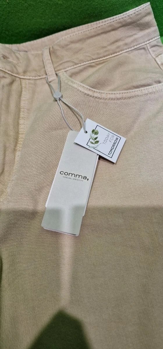 Pantalón beige con etiqueta de marca Comma