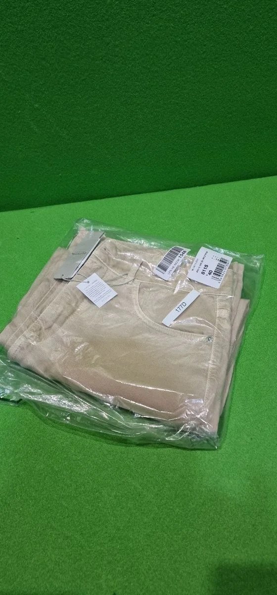 Pantalones beige empaquetados en plástico transparente.