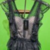 Vestido negro de encaje con tirantes en perchas.