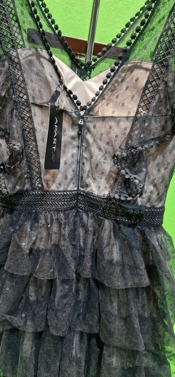 Vestido negro con encaje y volantes elegantemente diseñado.