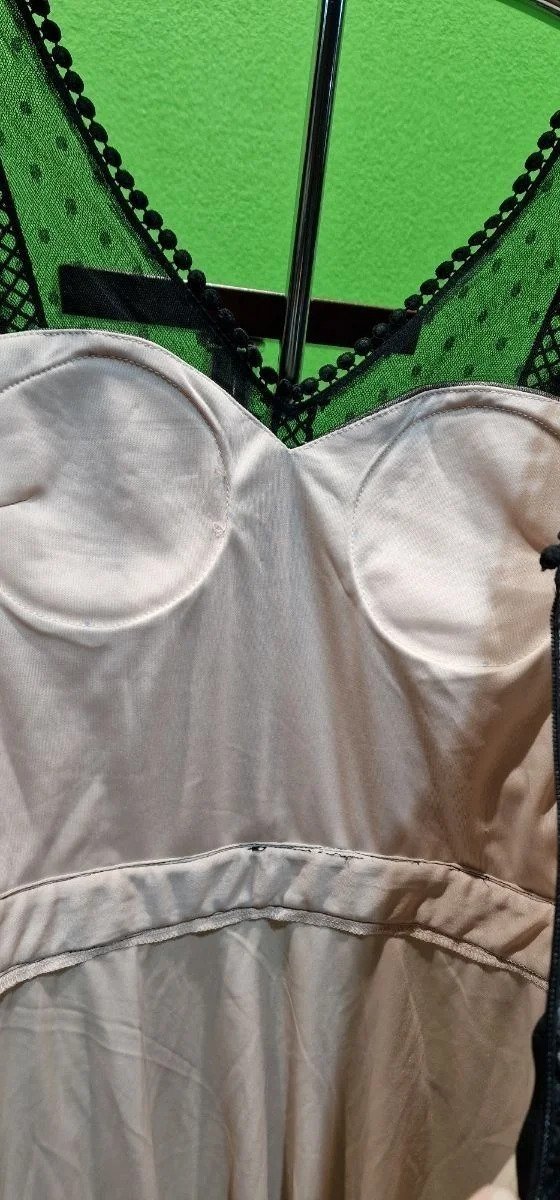 Corset blanco con encaje negro en percha.