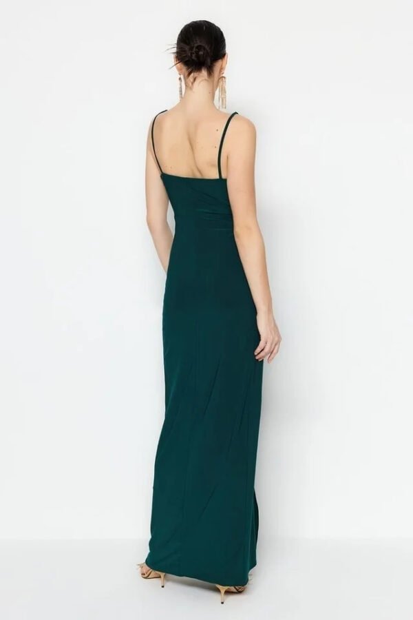 Mujer con vestido largo verde esmeralda elegante.