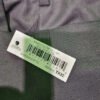 Etiqueta en pantalón gris con código de barras.