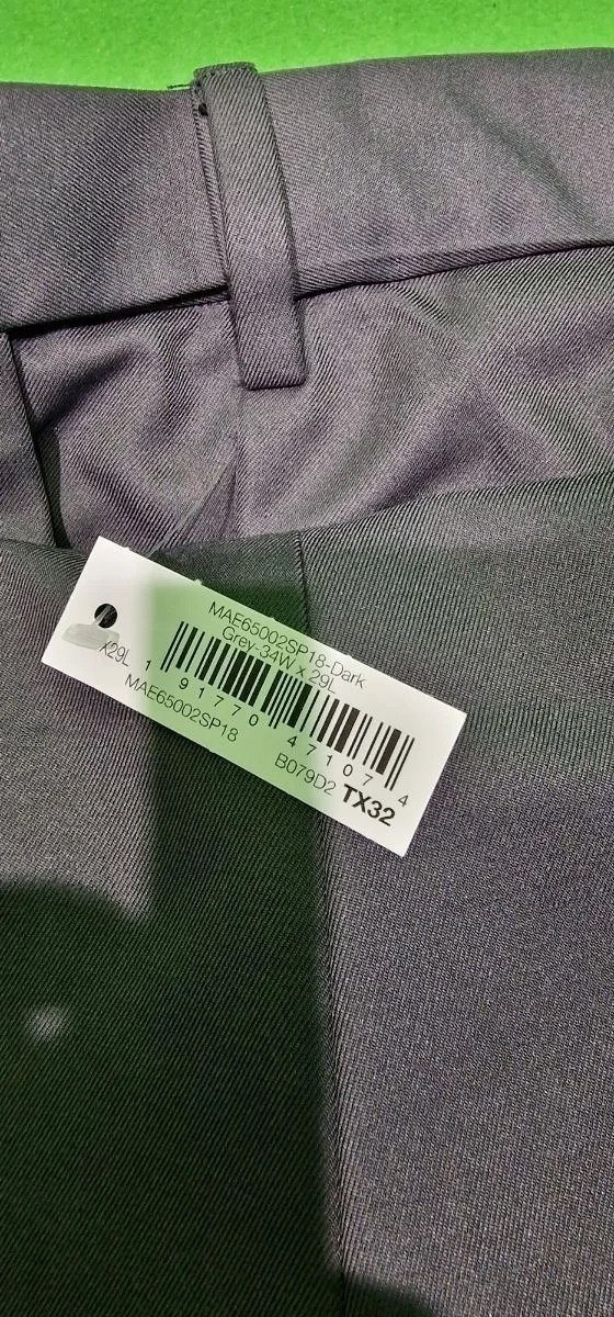 Etiqueta en pantalón gris con código de barras.