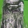 Camisa negra empaquetada en plástico transparente.
