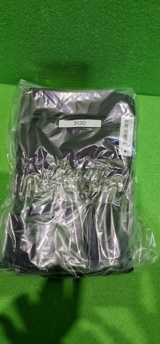 Camisa negra empaquetada en plástico transparente.