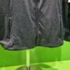 Chaqueta gris con cremallera en un expositor.
