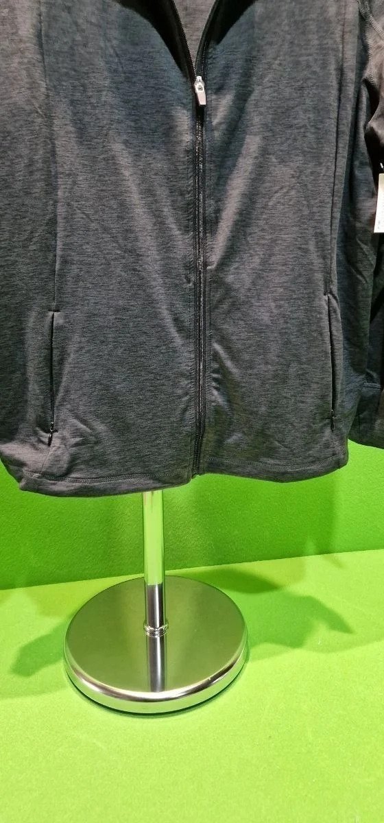 Chaqueta gris con cremallera en un expositor.