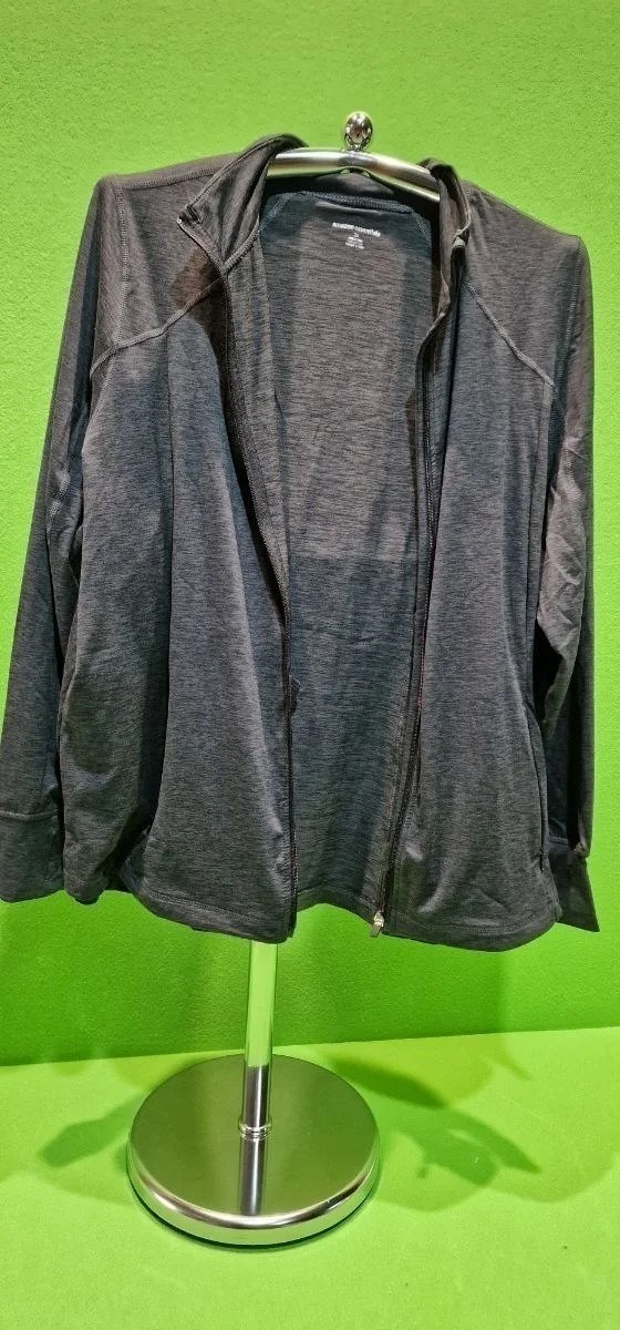 Chaqueta gris colgada en un perchero metálico.